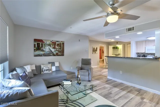 a living room with furniture and kitchen view