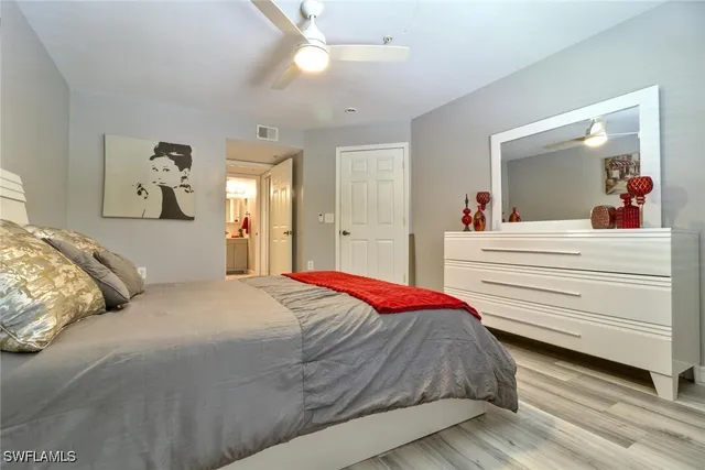 a bedroom with a large bed and a chandelier