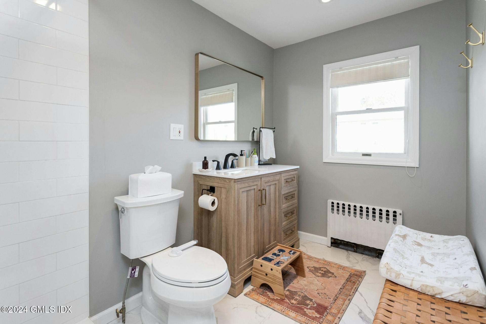 25 Bible Street, Unit 2 Cos Cob, CT 06807 - Photo 12 of 24 a bathroom with a sink toilet and a mirror