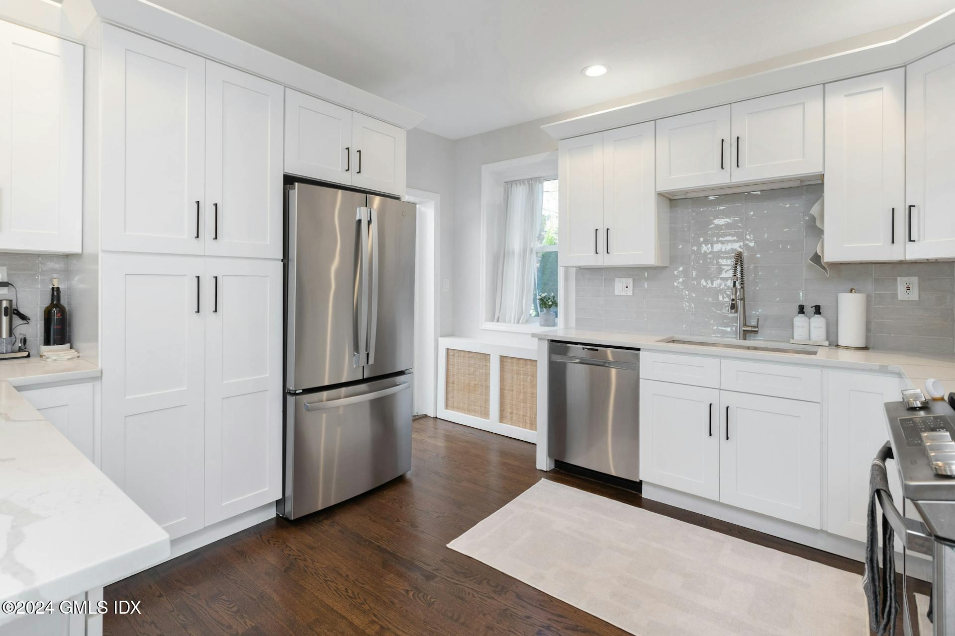 25 Bible Street, Unit 2 Cos Cob, CT 06807 - Photo 7 of 24 a kitchen with stainless steel appliances granite countertop a refrigerator sink and white cabinets