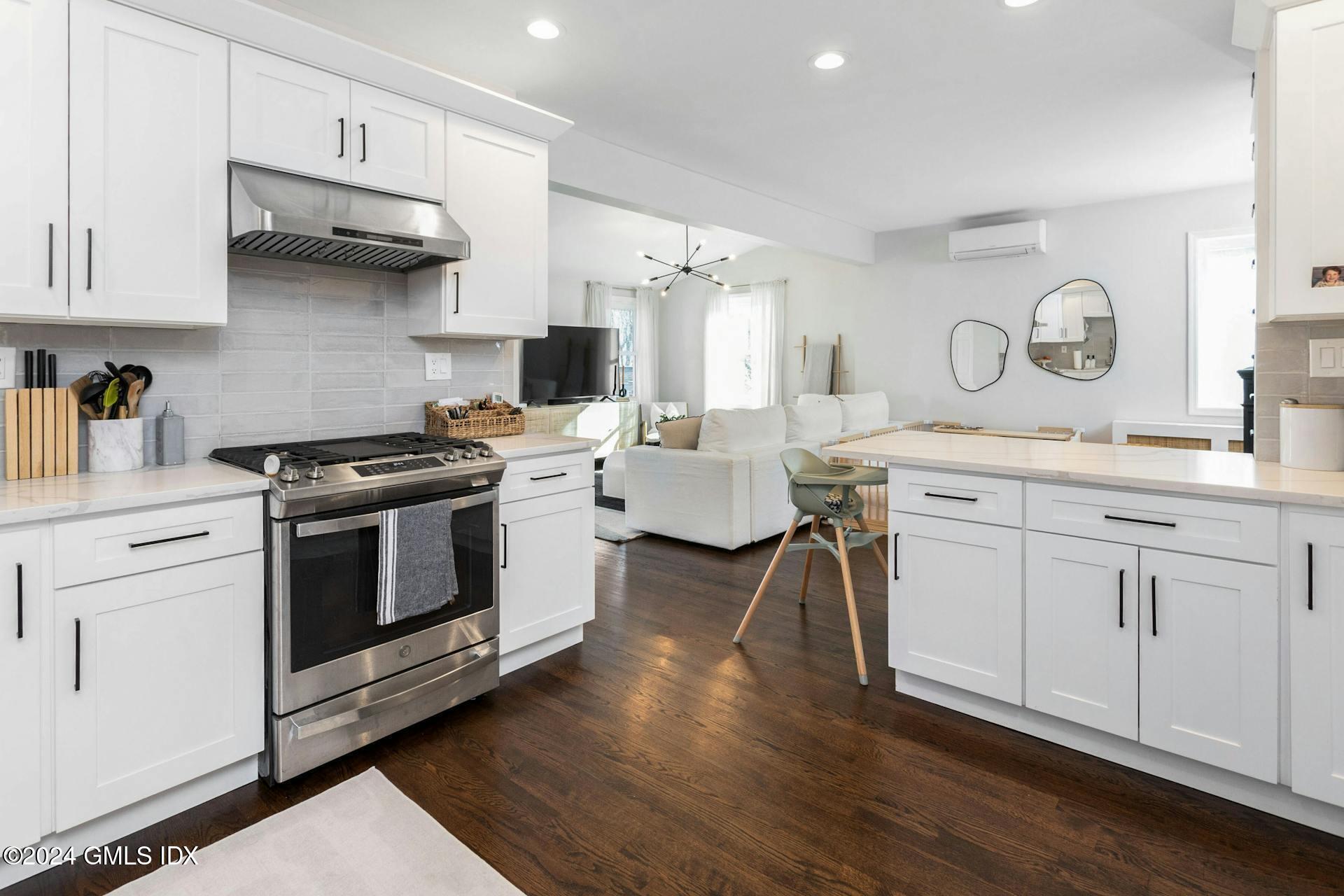 25 Bible Street, Unit 2 Cos Cob, CT 06807 - Photo 8 of 24 a kitchen with stainless steel appliances granite countertop a stove a sink dishwasher and white cabinets with wooden floor
