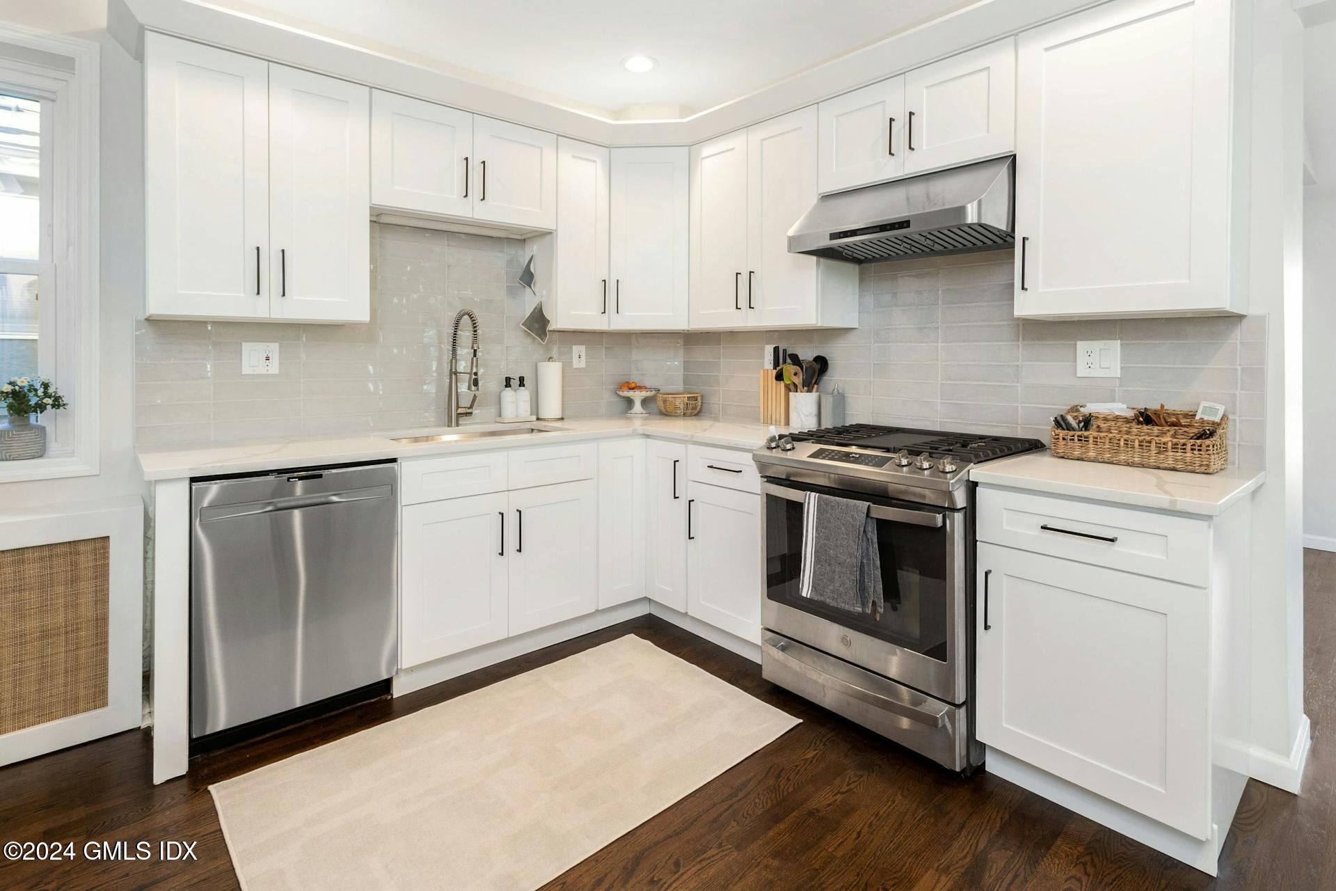 25 Bible Street, Unit 2 Cos Cob, CT 06807 - Photo 9 of 24 a kitchen with stainless steel appliances granite countertop a stove a sink and white cabinets