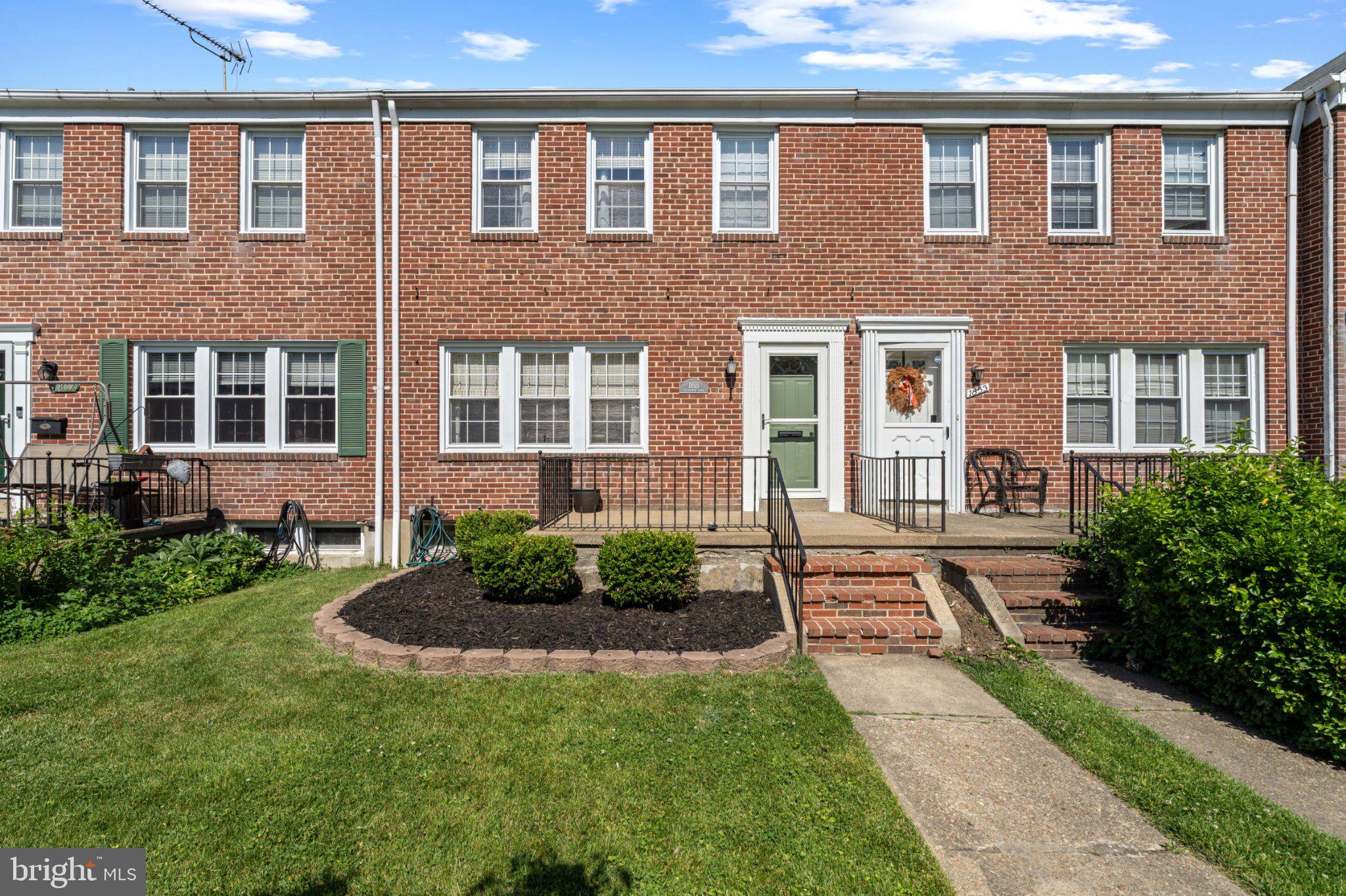 Charming brick townhouse with greenery.