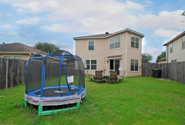 a front view of a house with garden and trees
