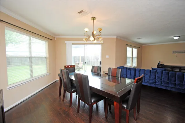 a view of a a dining room with furniture window and wooden floor