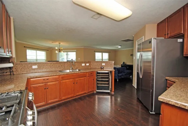 a large kitchen with stainless steel appliances a refrigerator and a stove top oven
