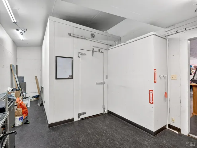 a view of a hallway with wooden floor and a living room