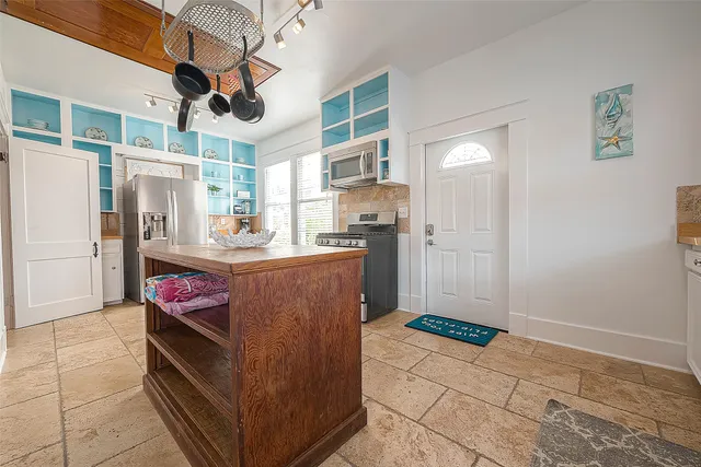 a kitchen with stainless steel appliances kitchen island granite countertop a refrigerator and a stove