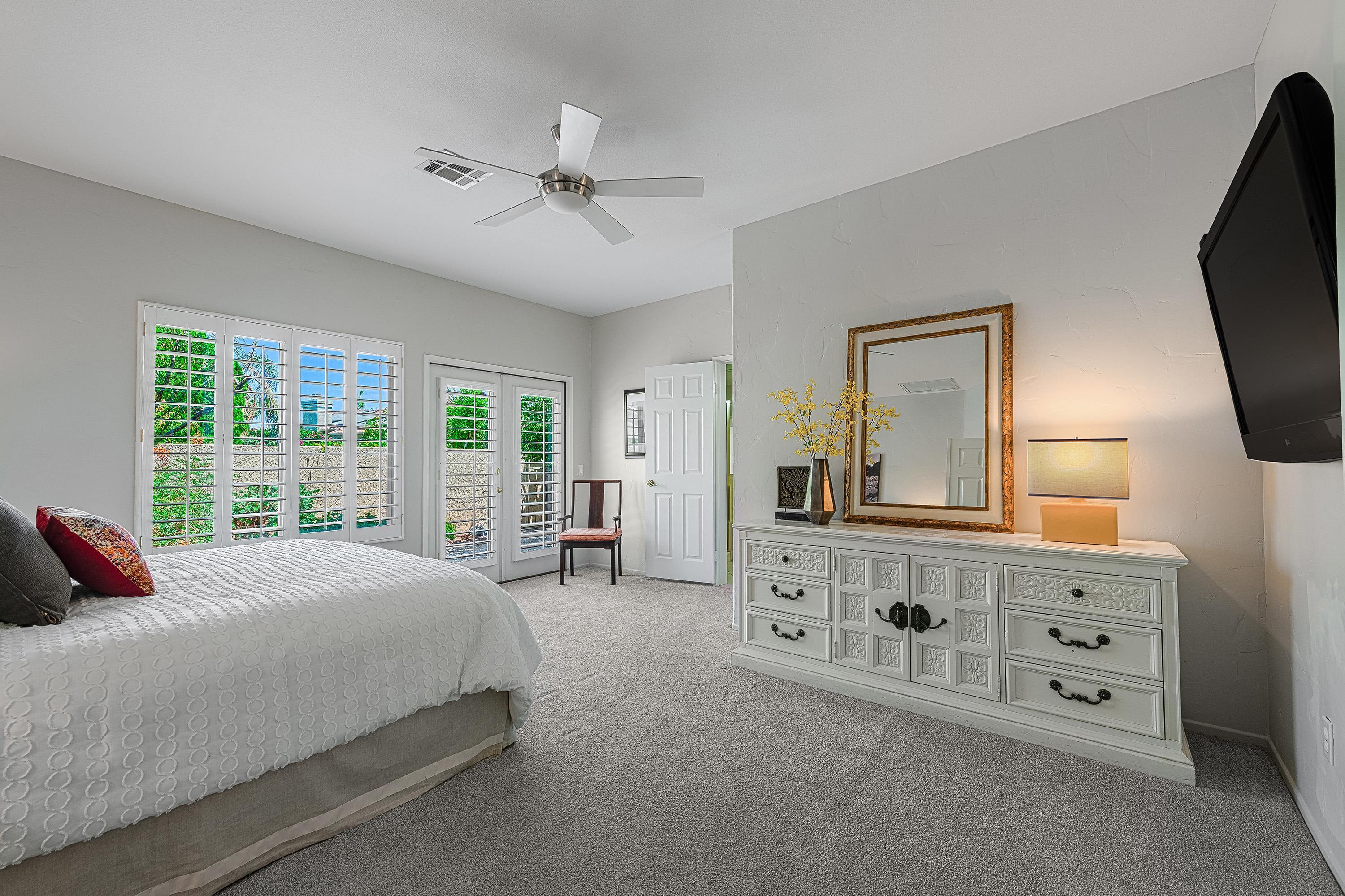 7 Florentina Drive Rancho Mirage, CA 92270 - Photo 16 of 45 a spacious bedroom with a large bed and a flat tv screen on dresser