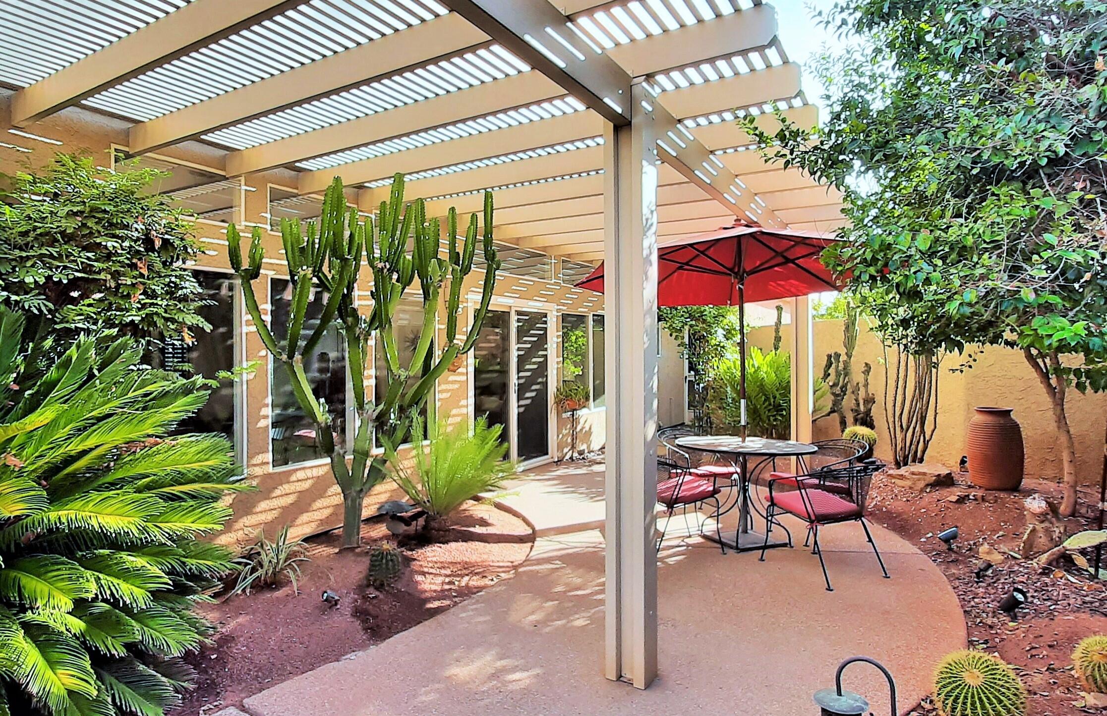 7 Florentina Drive Rancho Mirage, CA 92270 - Photo 22 of 45 a view of a patio with table and chairs potted plants and a large tree