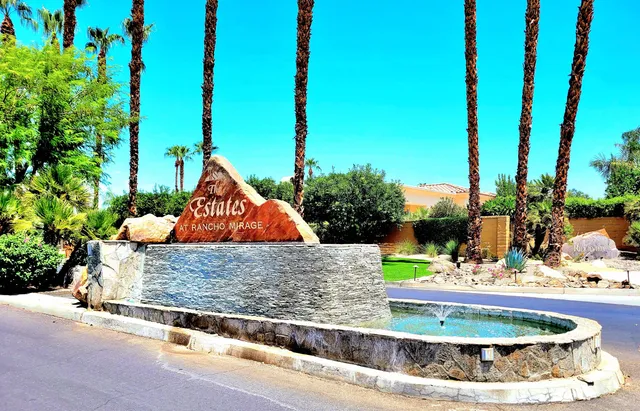 a view of a white house with a yard and potted plants