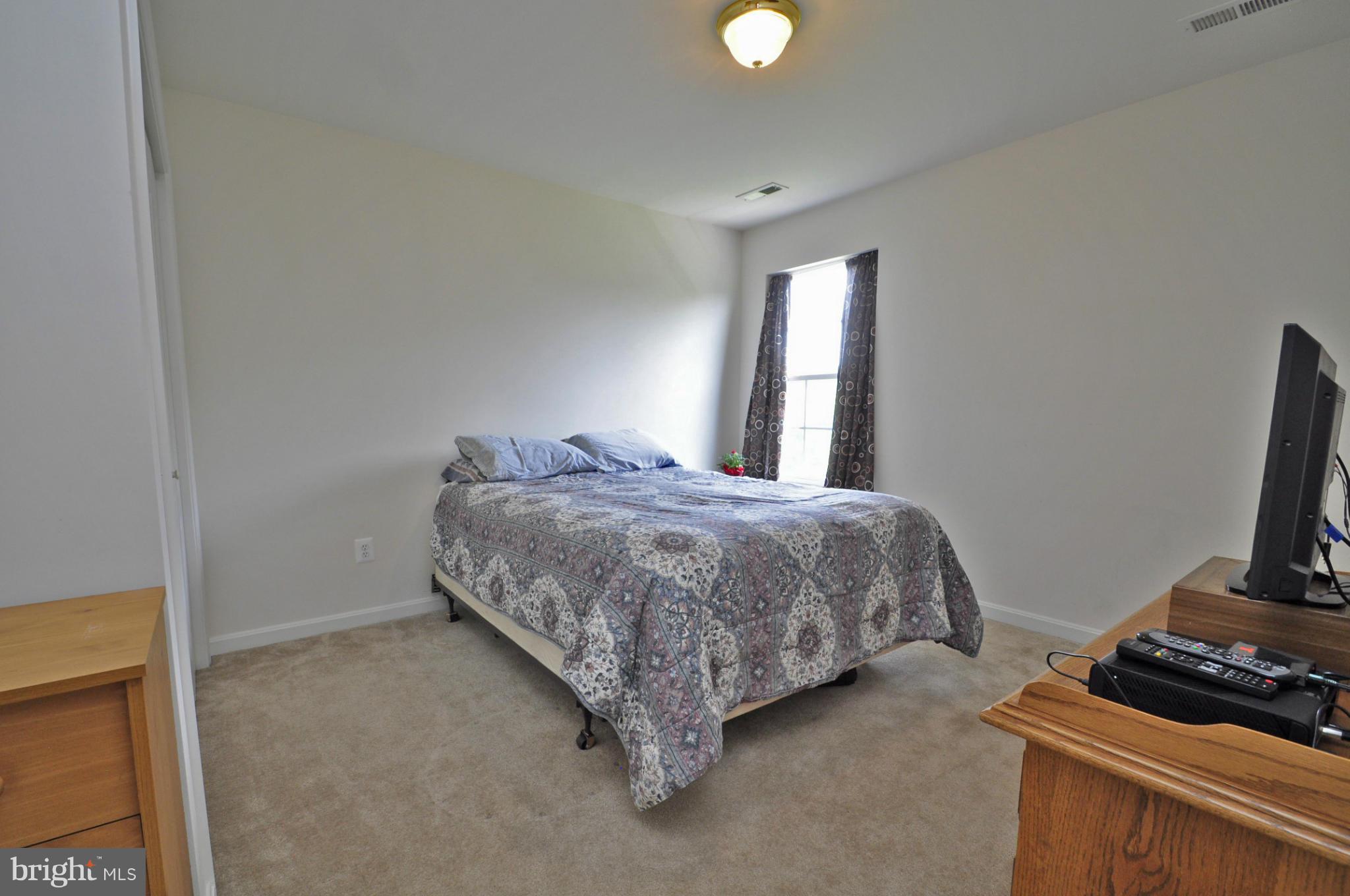 4625 Lewiston Road Bumpass, VA 23024 - Photo 14 of 30 a bedroom with a bed and a flat tv screen on a dresser