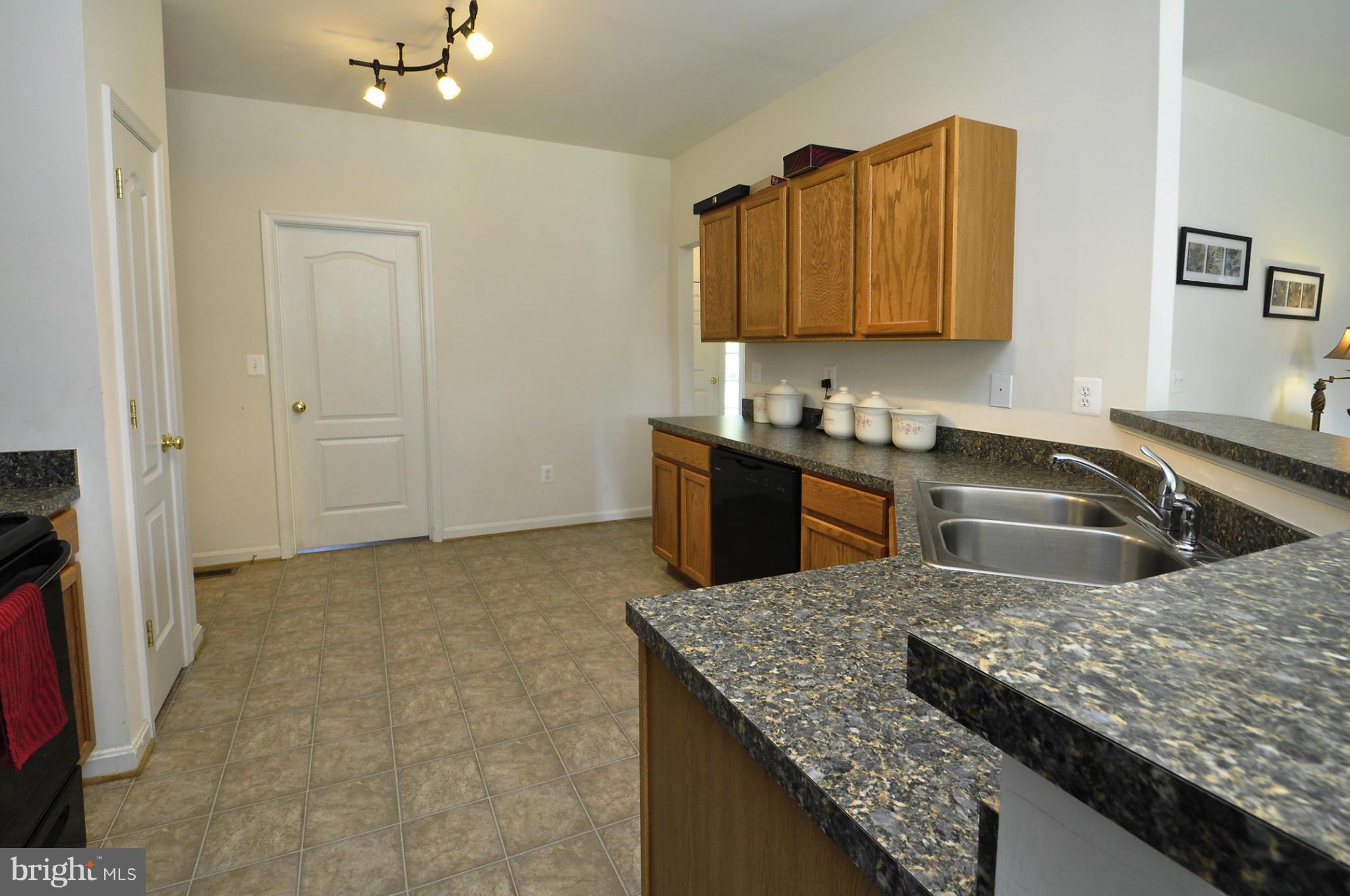 4625 Lewiston Road Bumpass, VA 23024 - Photo 3 of 30 a kitchen with granite countertop a sink a stove and cabinets