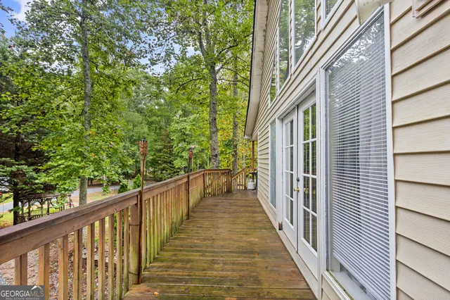 a view of a house with a small yard and large trees