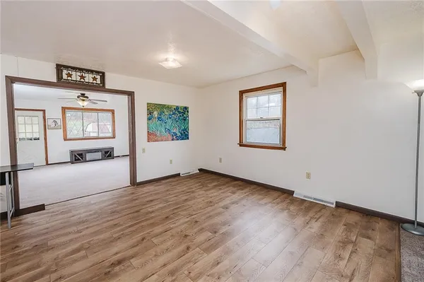 an empty room with windows & cabinet