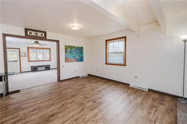 an empty room with windows & cabinet