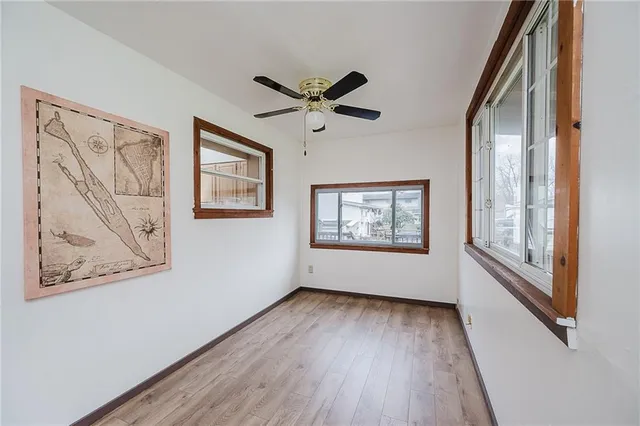 an empty room with window and ceiling fan