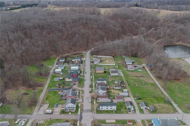 an aerial view of residential houses with outdoor space and parking