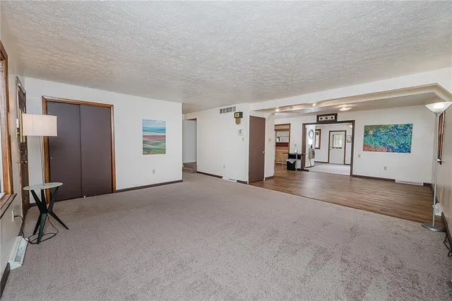 a kitchen with stainless steel appliances granite countertop a stove a sink dishwasher and white cabinets with wooden floor