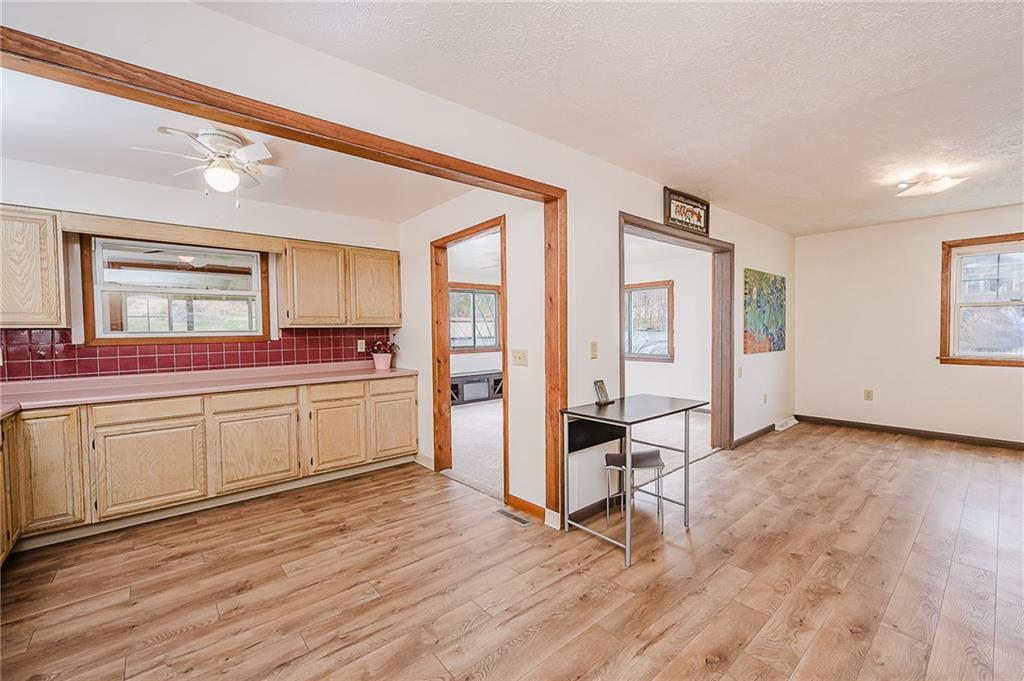 28 Indiana Avenue Avonmore, PA 15618 - Photo 9 of 49 a kitchen with stainless steel appliances granite countertop a stove a sink dishwasher and white cabinets with wooden floor