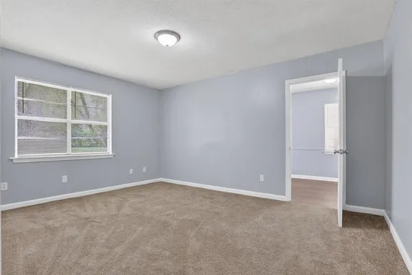 an empty room with windows and closet