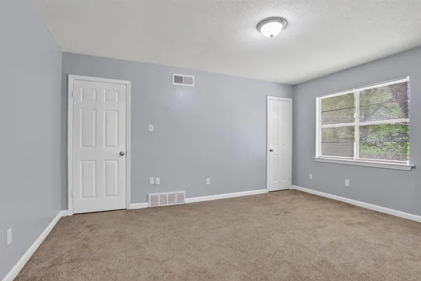 an empty room with windows and closet