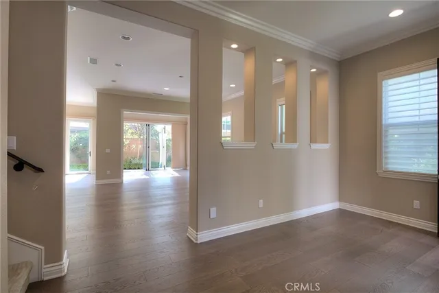 an empty room with wooden floor fireplace and windows