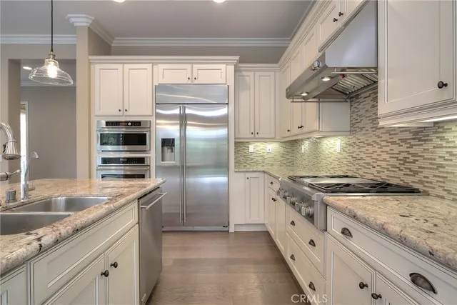 a kitchen with granite countertop a sink stainless steel appliances and cabinets