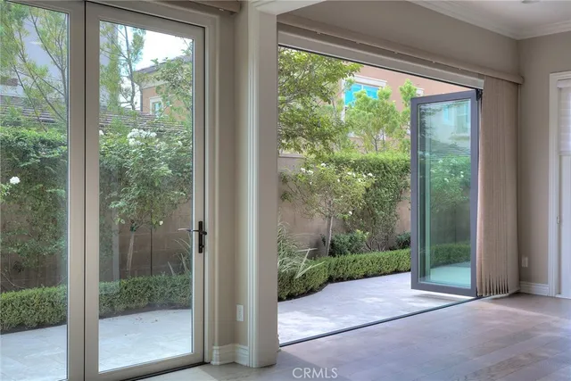 a view of a hallway with wooden floor and a kitchen