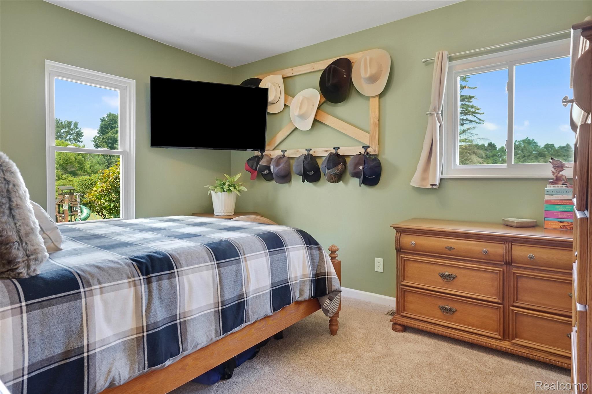 6050 Brophy Road Howell, MI 48855 - Photo 17 of 27 Room featuring two windows with white frames, light green wall paint, and neutral-toned carpeting