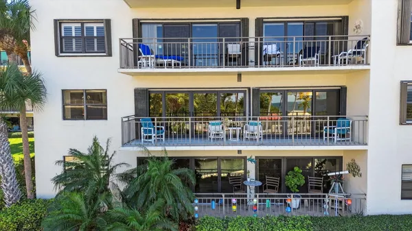 a view of building with large windows and plants