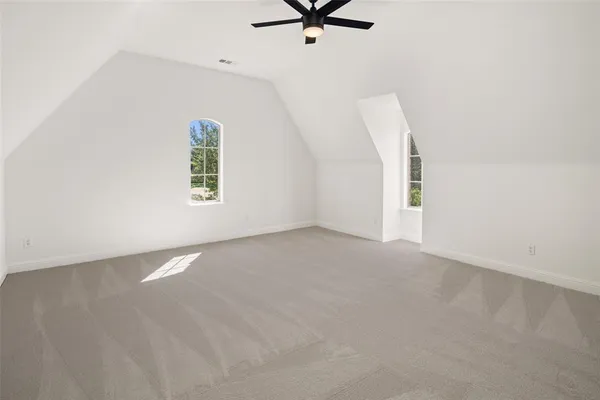 an empty room with a window and a ceiling fan