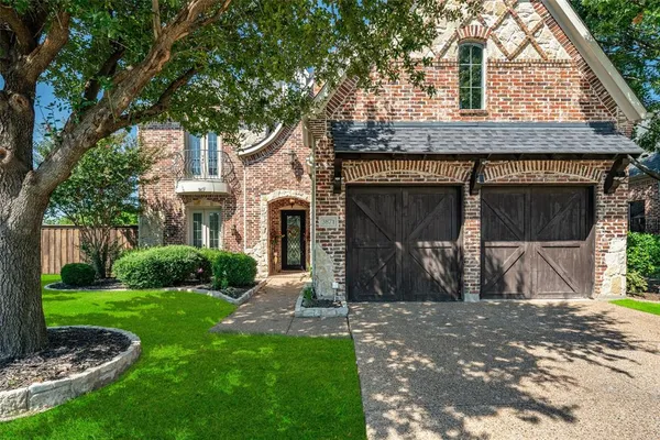 a front view of a house with yard and green space