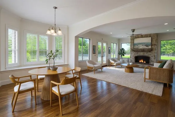 a living room with fireplace furniture and a large window