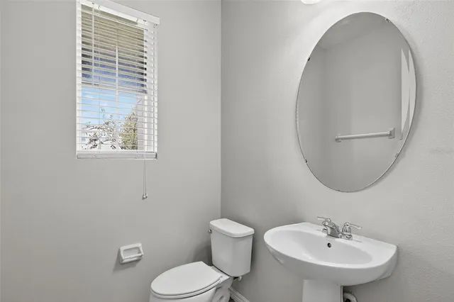 a bathroom with a toilet a sink and mirror