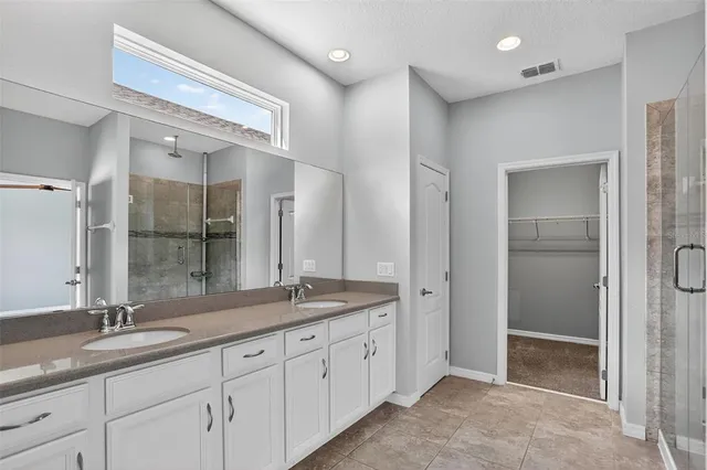 a spacious bathroom with a granite countertop sink mirror and shower