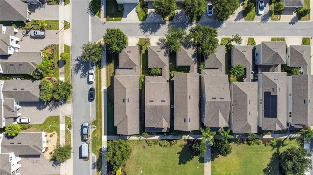 an aerial view of a residential apartment building with plants and large trees
