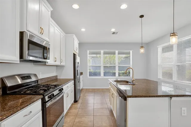 a kitchen with stainless steel appliances granite countertop a sink and a stove