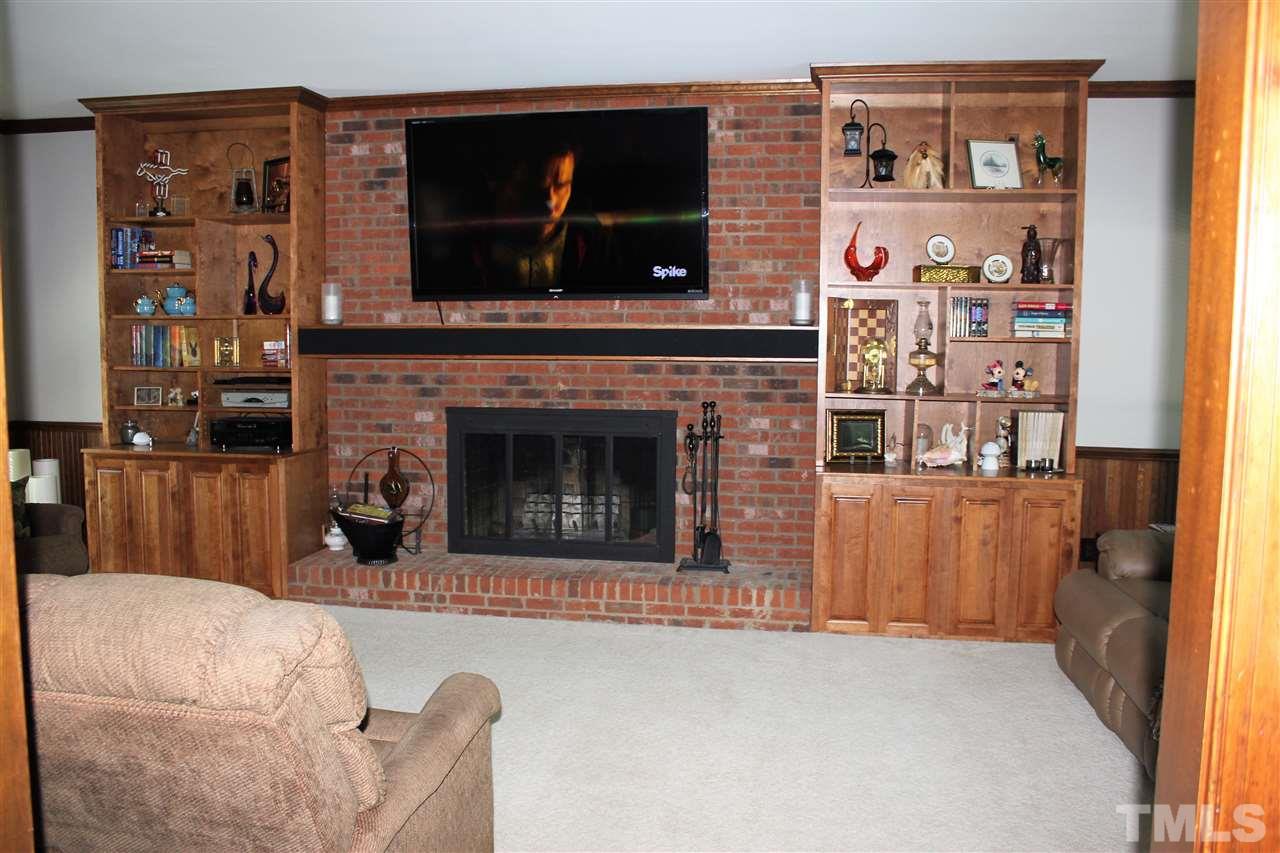 9504 Springdale Drive Raleigh, NC 27613 - Photo 2 of 25 a living room with furniture a flat screen tv and a fireplace