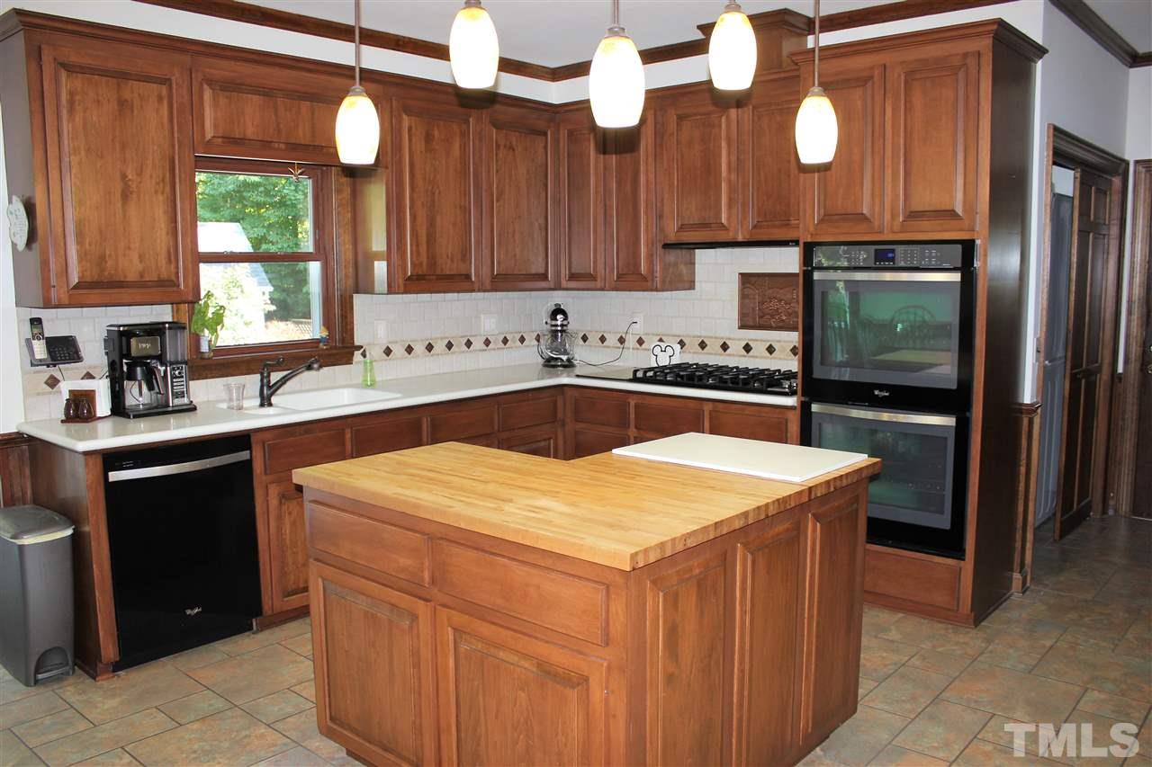 9504 Springdale Drive Raleigh, NC 27613 - Photo 7 of 25 a kitchen with a sink dishwasher a stove and a refrigerator