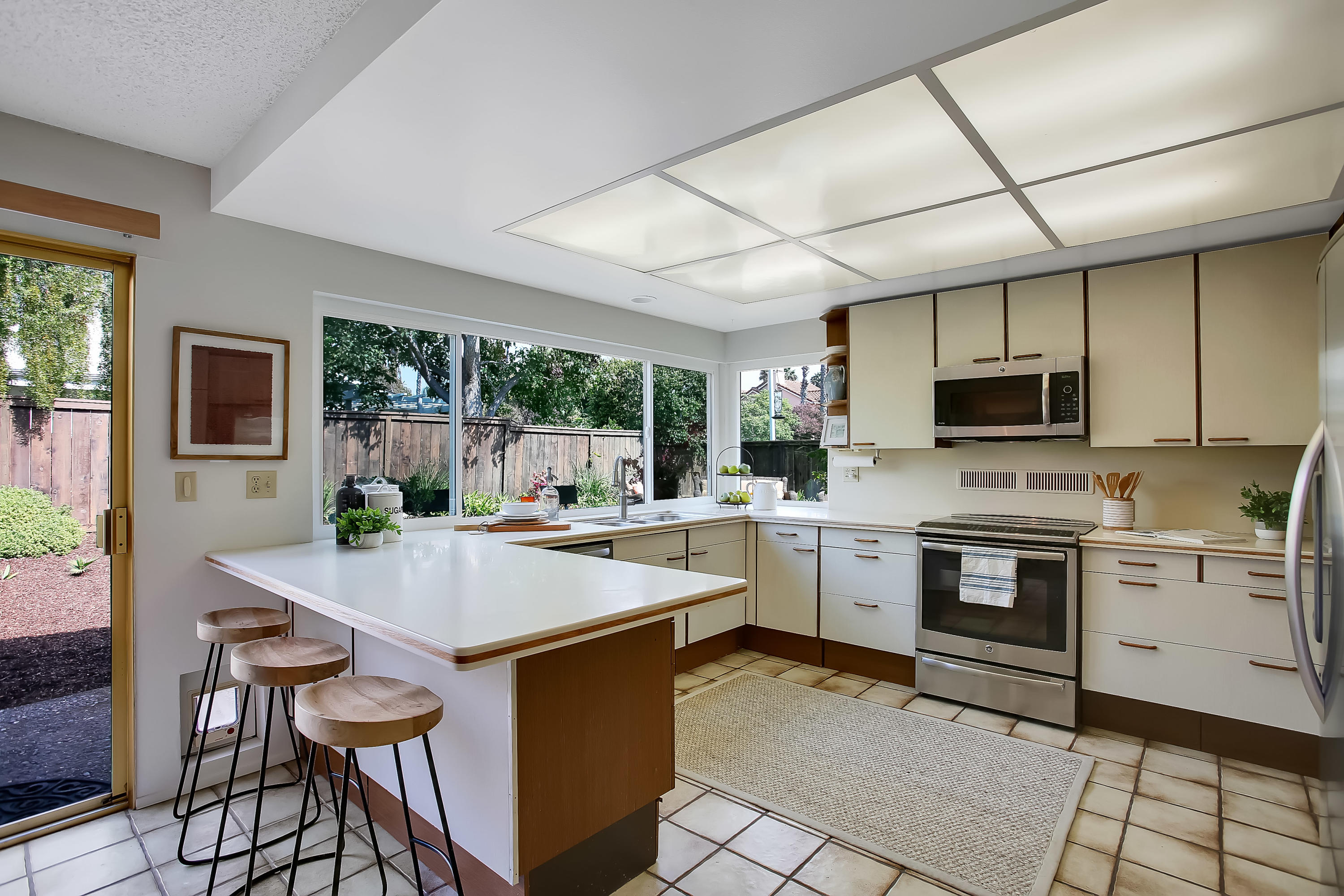 7206 Georgetown Road Goleta, CA 93117 - Photo 9 of 34 a kitchen with a stove a sink dishwasher a oven with a dining table and chairs