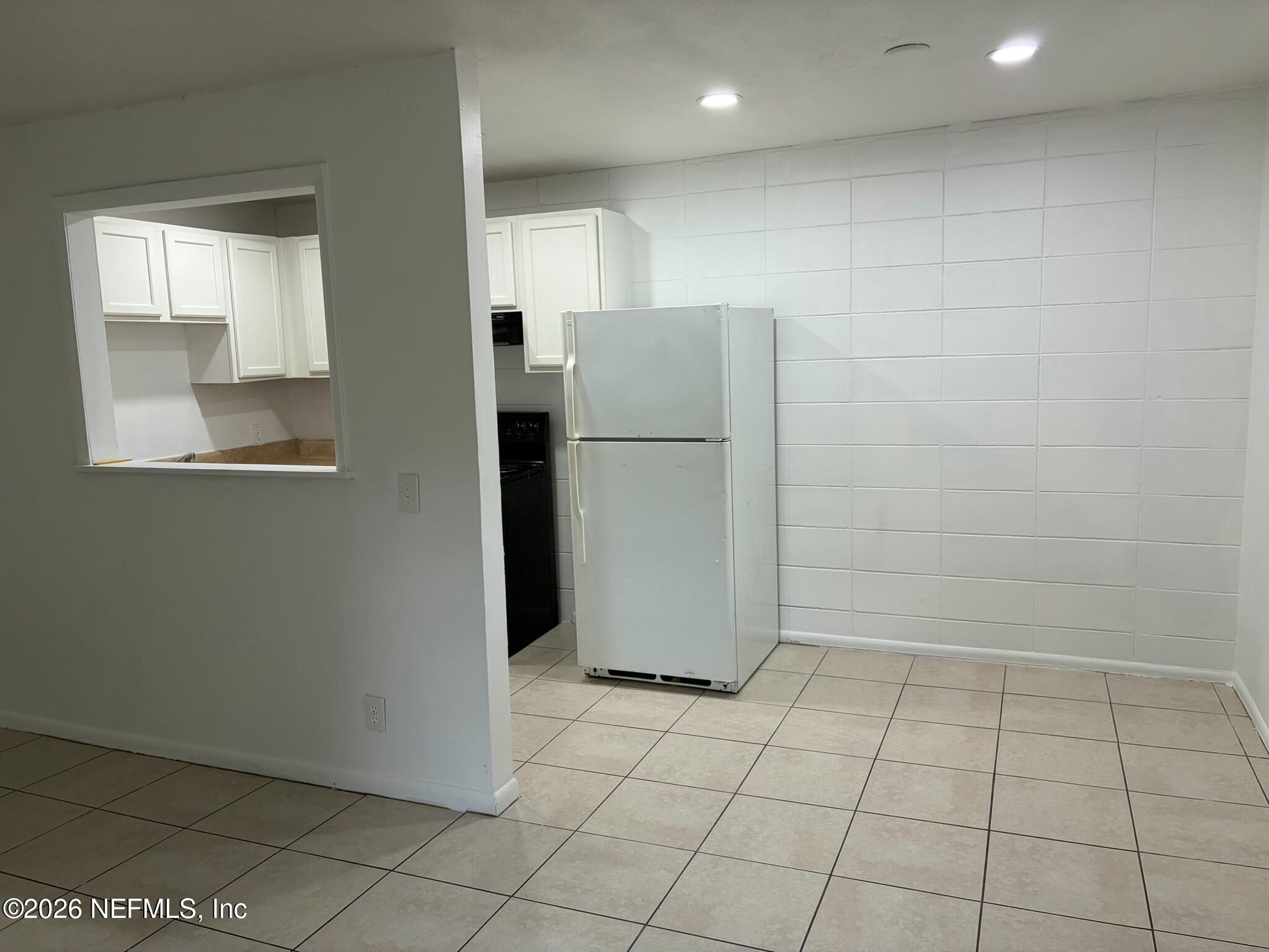 1040 Bert Road, Unit 5 Jacksonville, FL 32211 - Photo 3 of 5 a view of a refrigerator in kitchen and an empty room