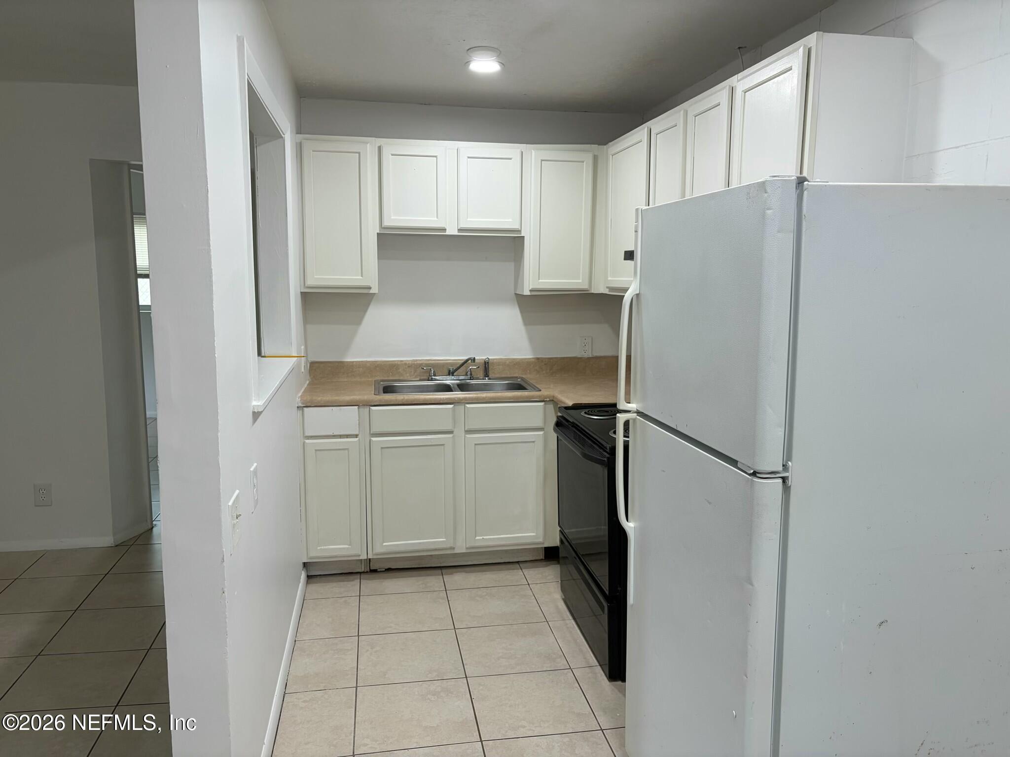 1040 Bert Road, Unit 5 Jacksonville, FL 32211 - Photo 4 of 5 a kitchen with a refrigerator sink and cabinets