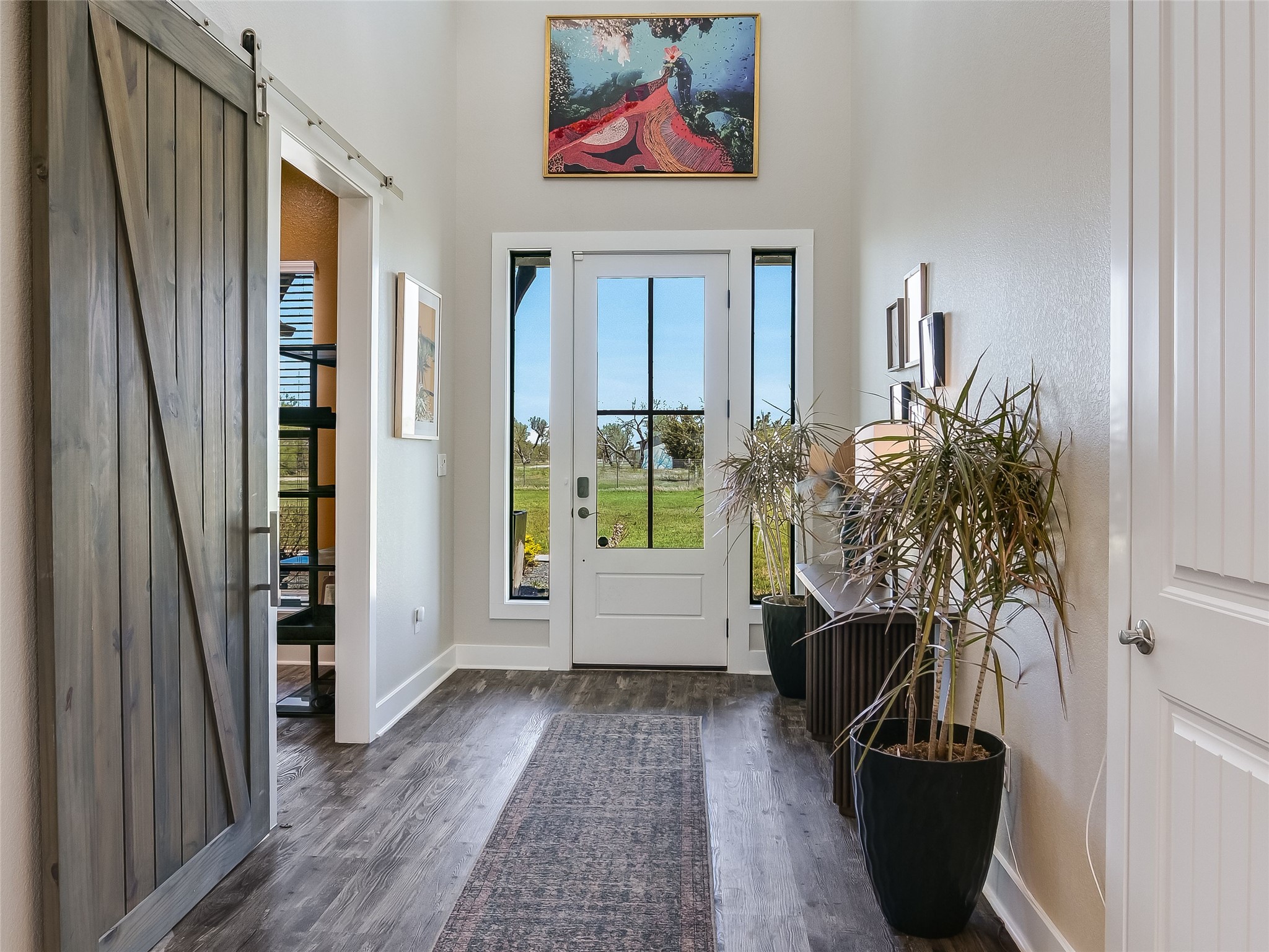 19819 Lockwood Road Manor, TX 78653 - Photo 5 of 29 The bright and welcoming entryway, framed by sidelights and transom windows, sets the stage with natural light and rustic-modern charm.