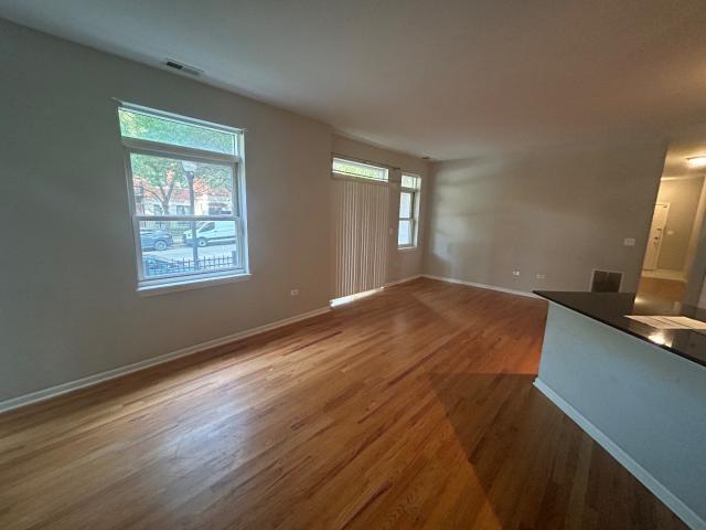 1461 South Halsted Street, Unit 1B Chicago, IL 60607 - Photo 19 of 20 a view of a room with wooden floor and a window