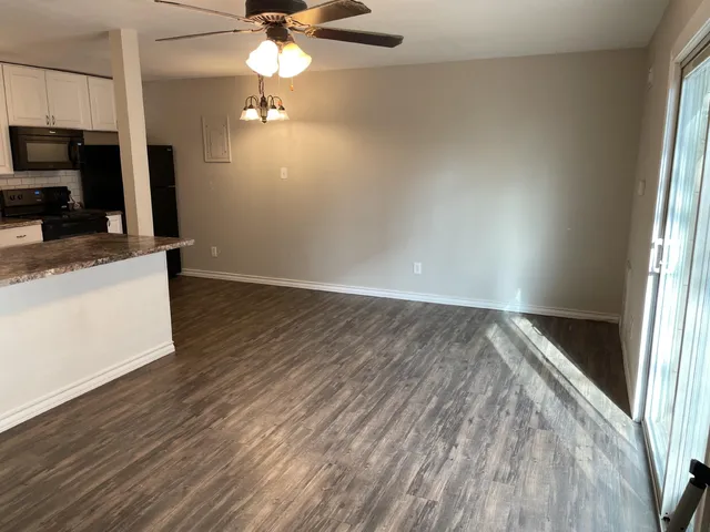 a view of a kitchen with wooden floor a sink and a window