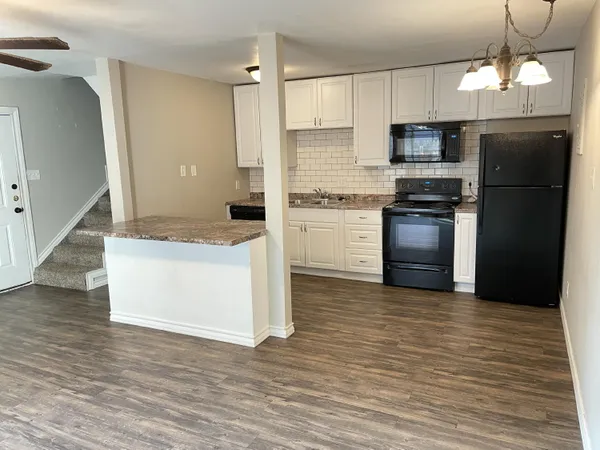 a kitchen with stainless steel appliances granite countertop a refrigerator a stove and a microwave oven