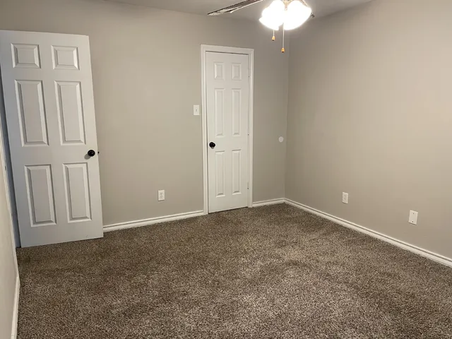 an empty room with a chandelier fan