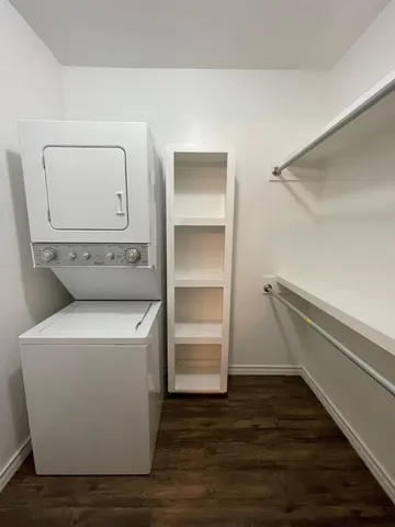a utility room with wooden floor washer and dryer