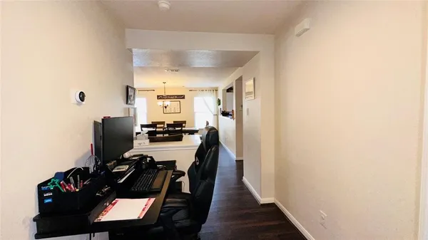 a view of a hallway with workspace and a window